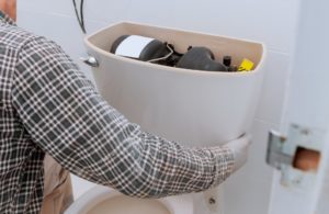 emergency plumber fixing a toilet